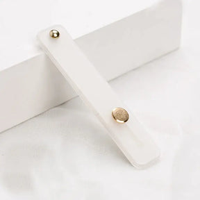 A white wooden box with a gold button