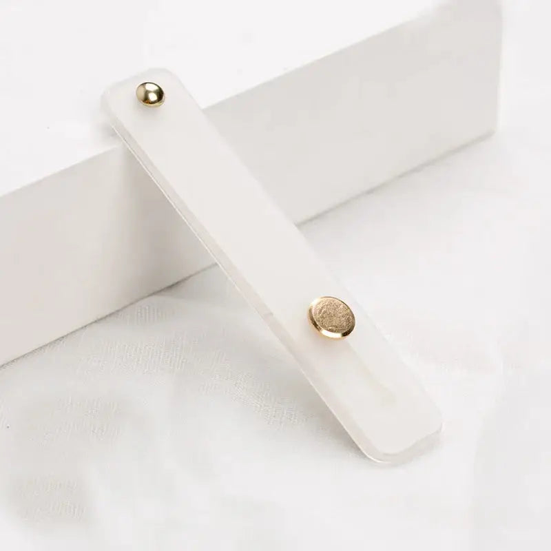 a white wooden box with a gold button