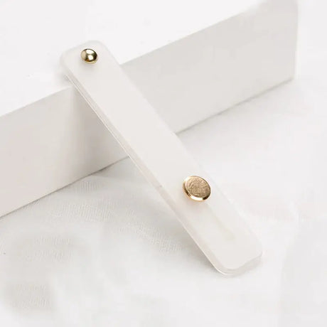 A white wooden box with a gold button