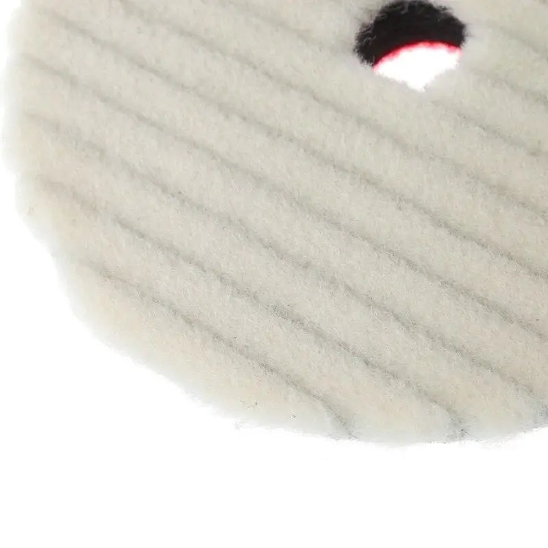 a white wool pad with a red dot