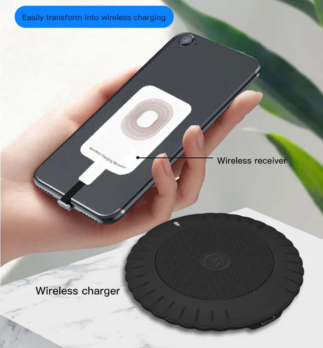 Wireless charging adapter attached to a smartphone, with a separate wireless charging pad shown below.