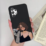 a woman in a black dress holding a phone case