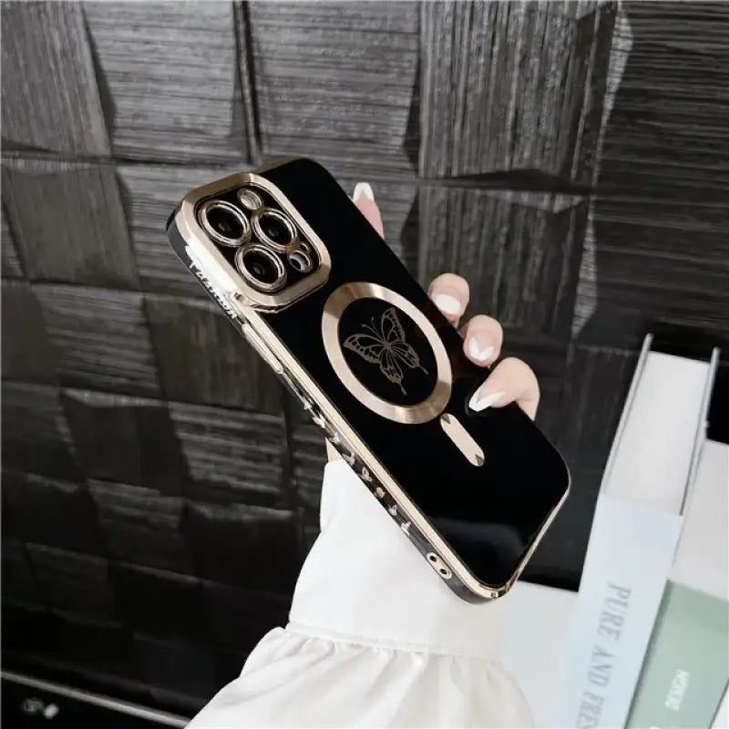 A woman holding a black and gold iphone case