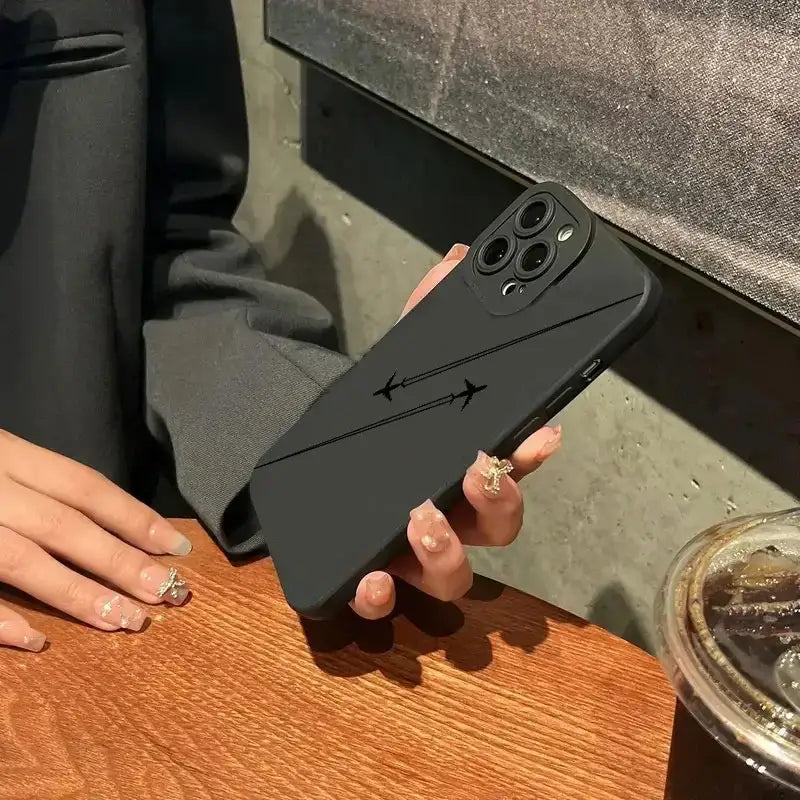 a woman holding a black iphone case
