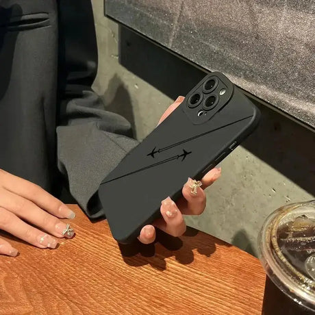 A woman holding a black iphone case