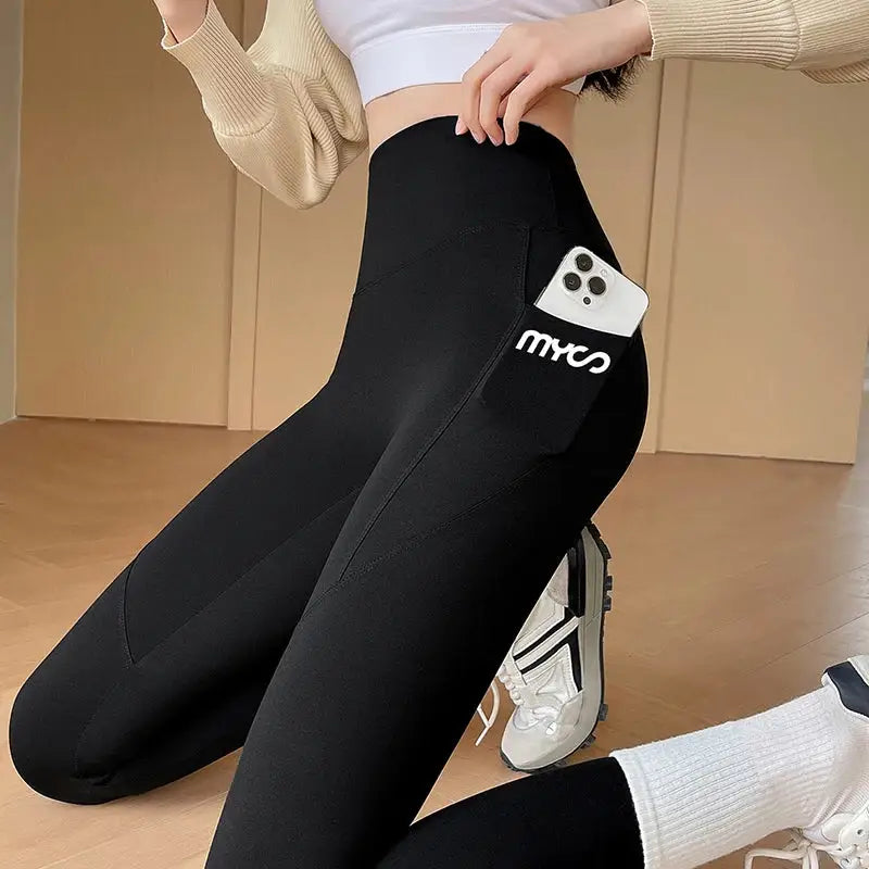 a woman wearing black leggings with white logo