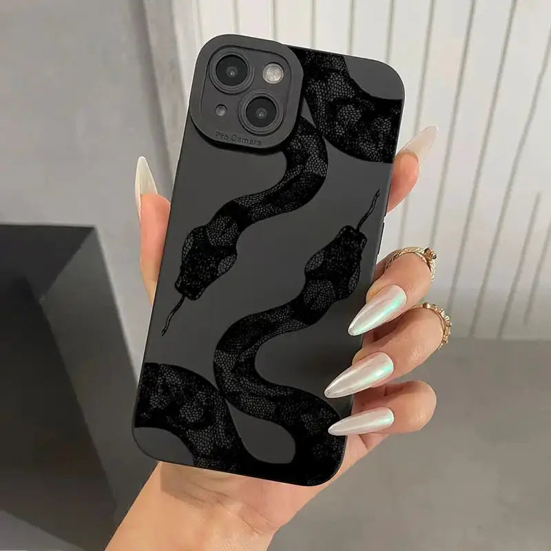 a woman holding a black phone case with a snake pattern