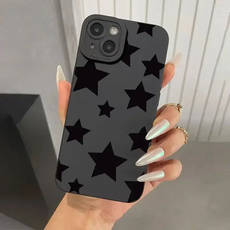 A woman holding a black phone case with stars on it