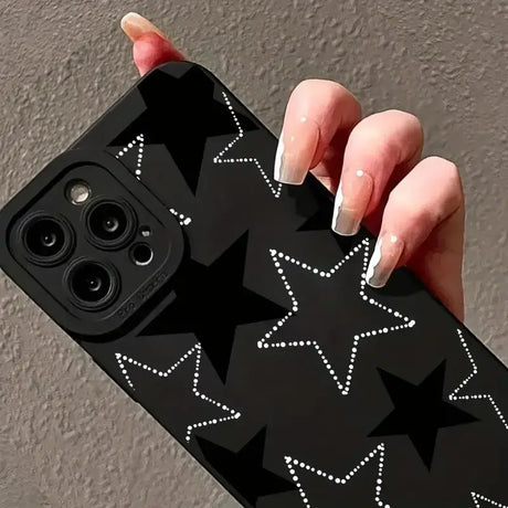 A woman holding a black phone case with stars on it