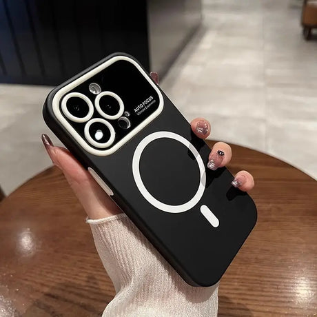 a woman holding a black phone case with a white circle on it