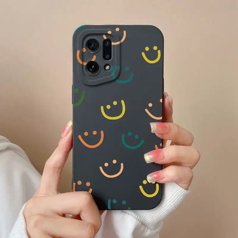 a woman holding a black phone case with colorful smiley faces