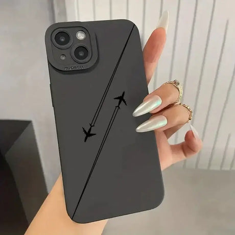 A woman holding a black phone case with an airplane on it