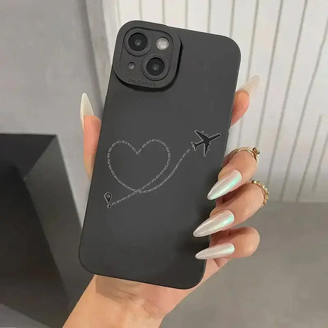 A woman holding a black phone case with a heart drawn on it