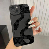 A woman holding a black phone case with a snake on it