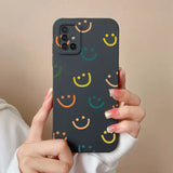a woman holding a black phone case with colorful smiley faces