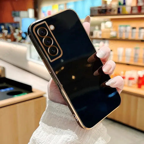 A woman holding a black phone in her hand