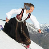 a woman in a black skirt skiing down a hill