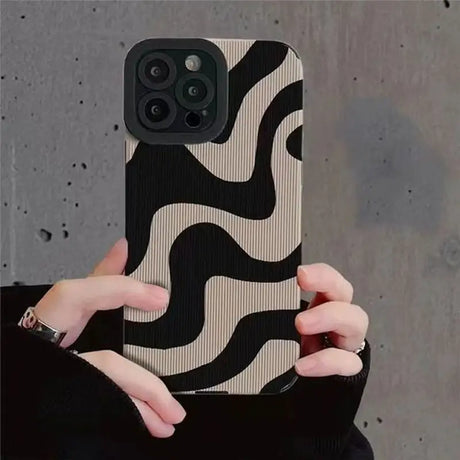 A woman holding a black and white phone case