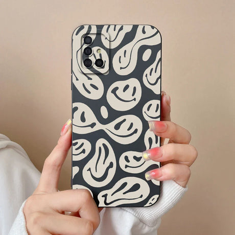 a woman holding up a black and white phone case