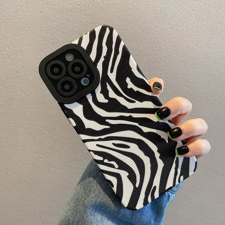 A woman holding a black and white zebra print phone case