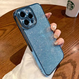 a woman holding a blue glitter iphone case