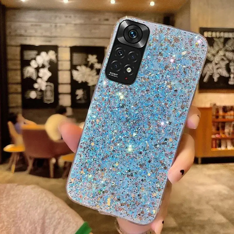 A woman holding up a blue glitter phone case