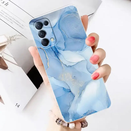 A woman holding a blue marble phone case with a pink nail polish