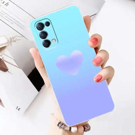 A woman holding a blue phone case with a heart on it