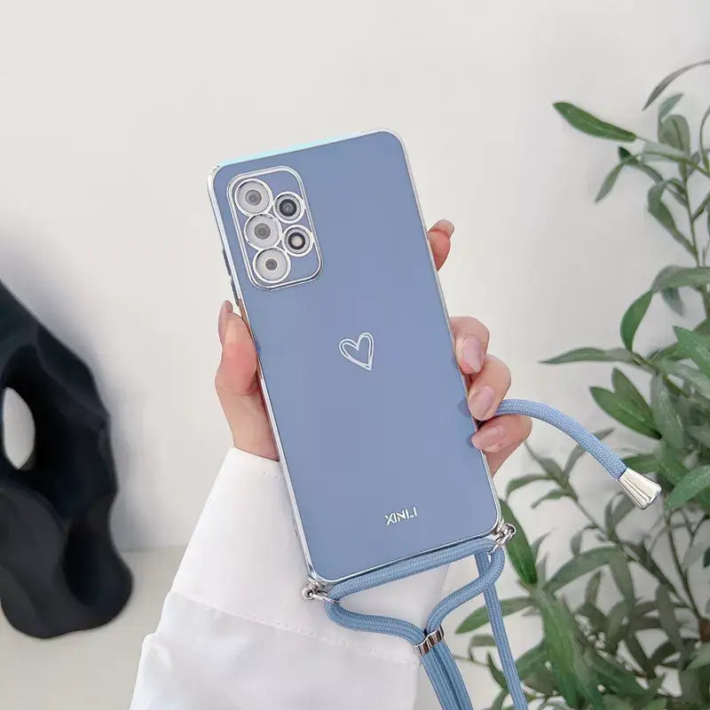 a woman holding a blue phone case with a heart on it