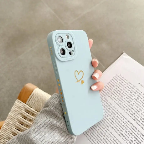 A woman holding a blue phone case with a heart on it