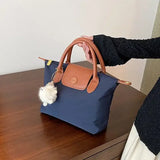 a woman holding a blue purse on a table