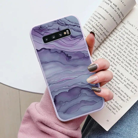a woman holding a book and a phone case