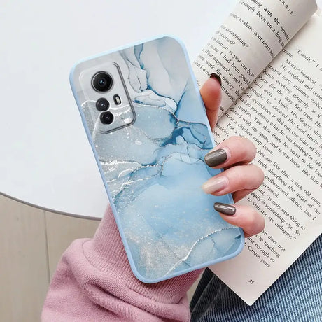 A woman holding a book and holding a phone case