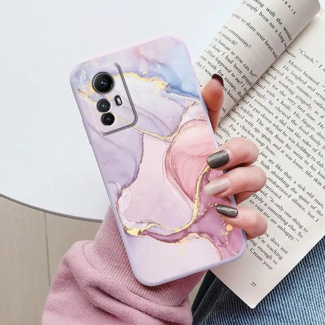 A woman holding a book and a phone case