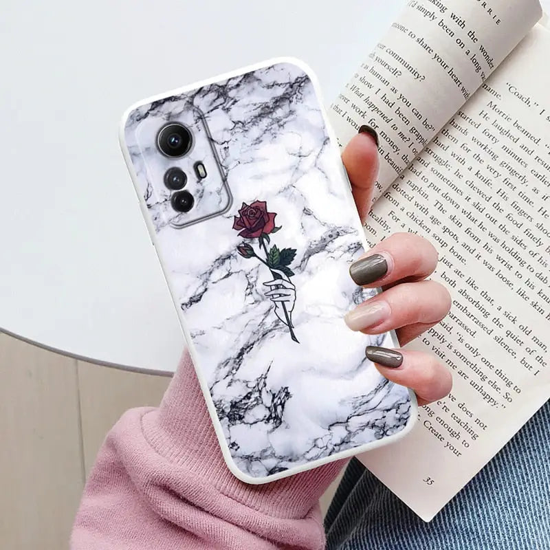 A woman holding a book and a phone case