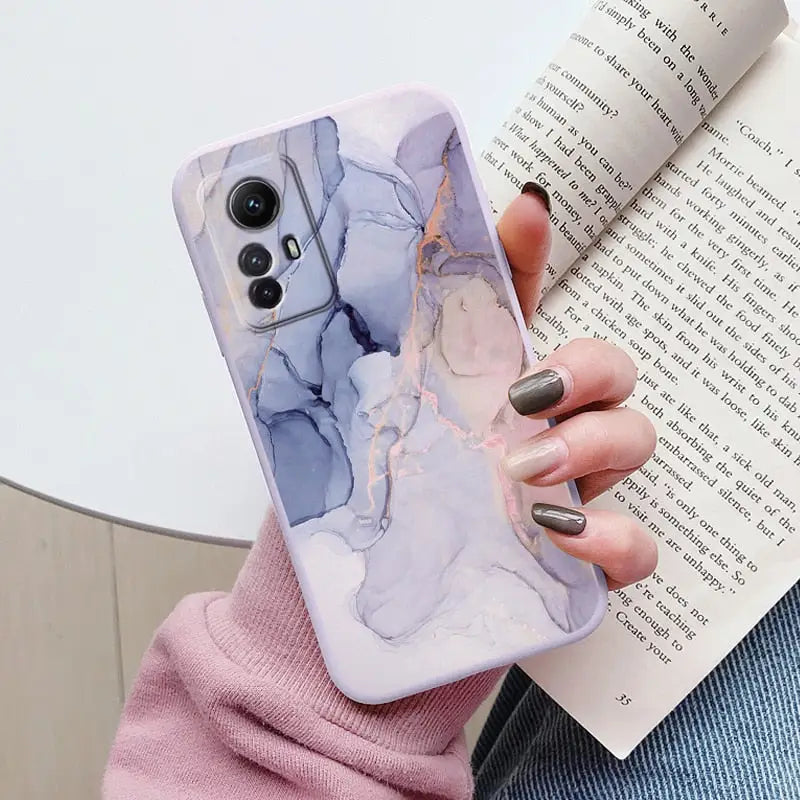 a woman holding a book and a phone case