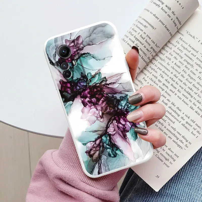 a woman holding a book and a phone case