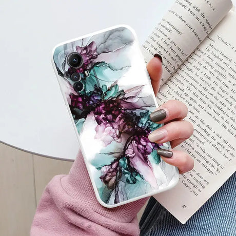 A woman holding a book and a phone case