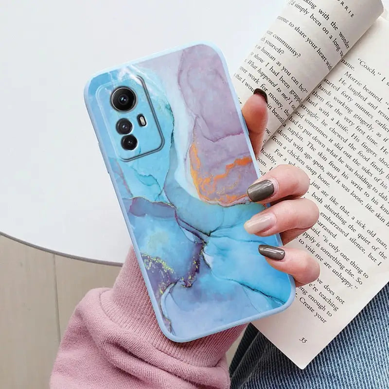 A woman holding a book and holding a phone case