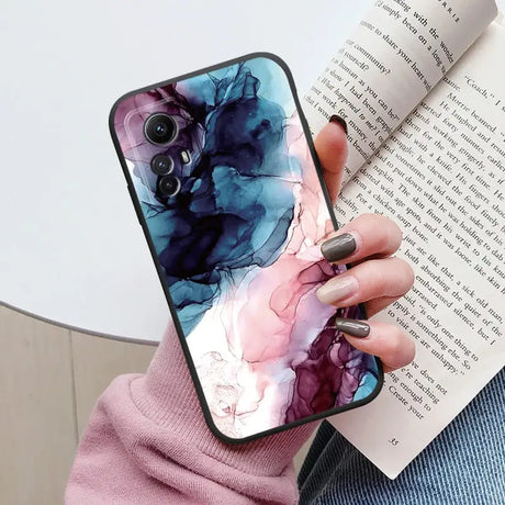 A woman holding a book and holding a phone case