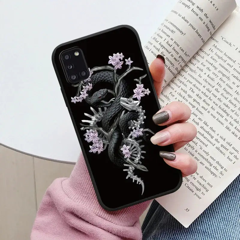 A woman holding a book and a phone case