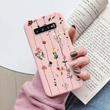 a woman holding a book and a pink phone case