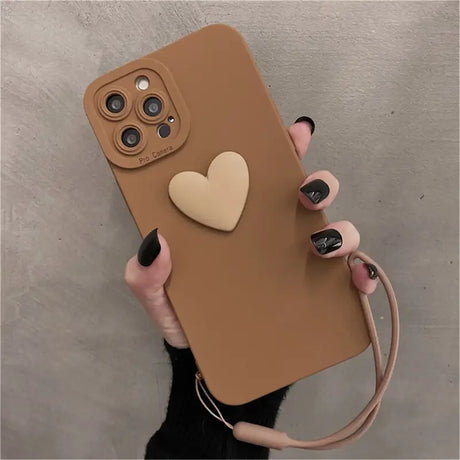 A woman holding a brown phone case with a heart on it