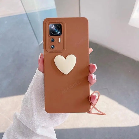 A woman holding a brown phone case with a heart on it