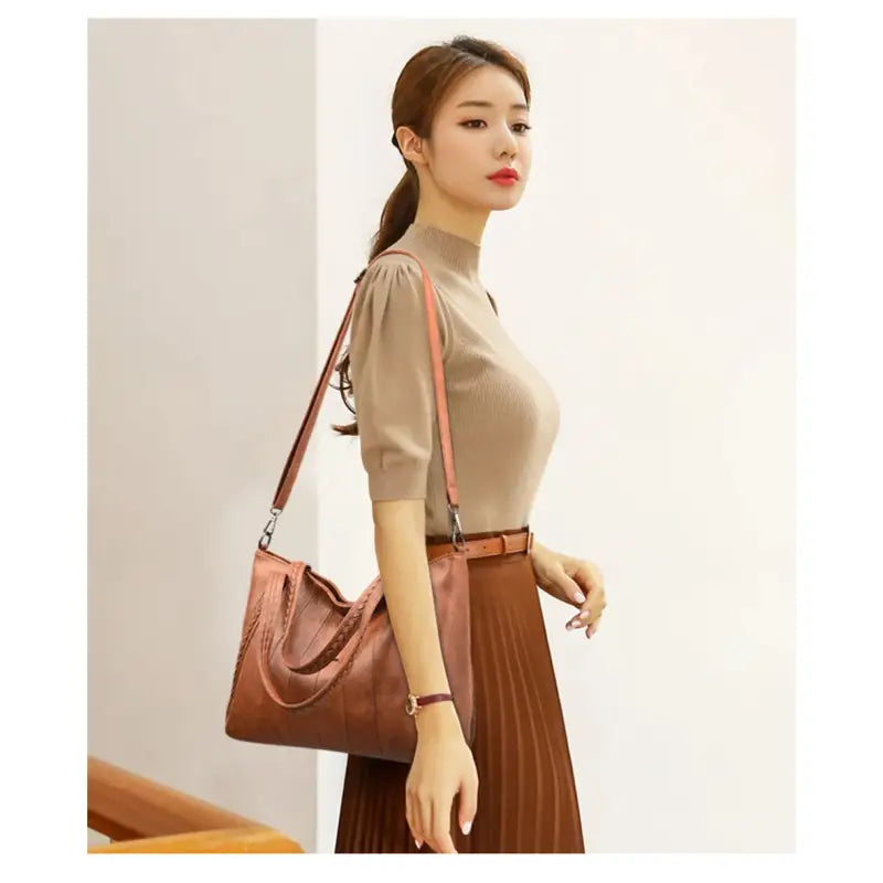 a woman in a brown top and brown skirt holding a brown bag
