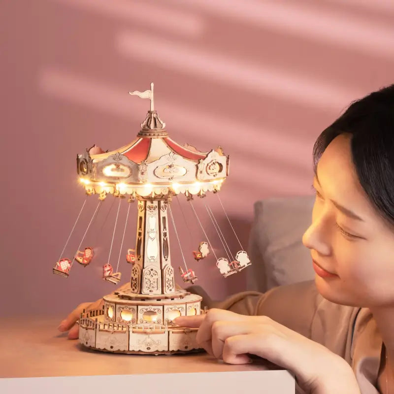 a woman is sitting on a bed and looking at a carousel