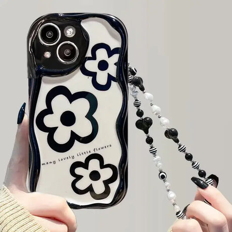 A woman holding a cell case with a black and white design