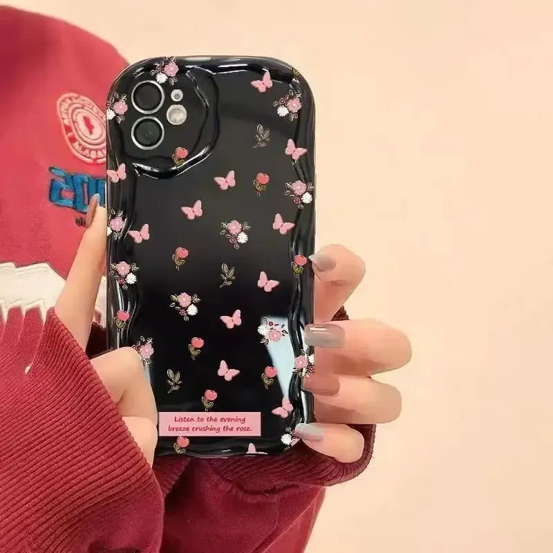 A woman holding a cell phone case with flowers on it