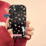 a woman holding a cell phone case with flowers on it