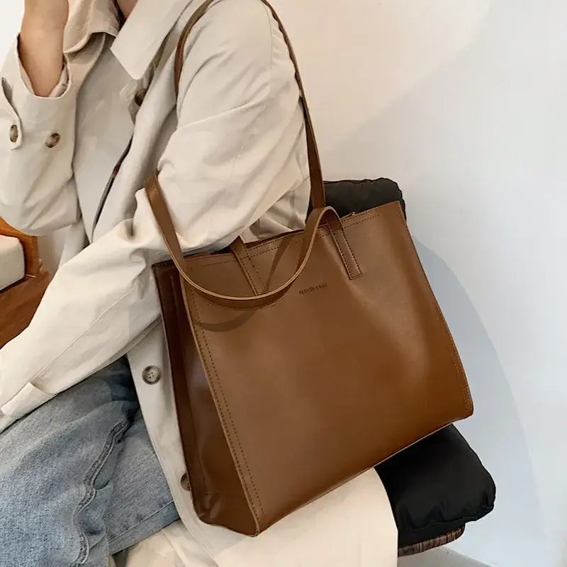 a woman sitting on a chair holding a brown bag